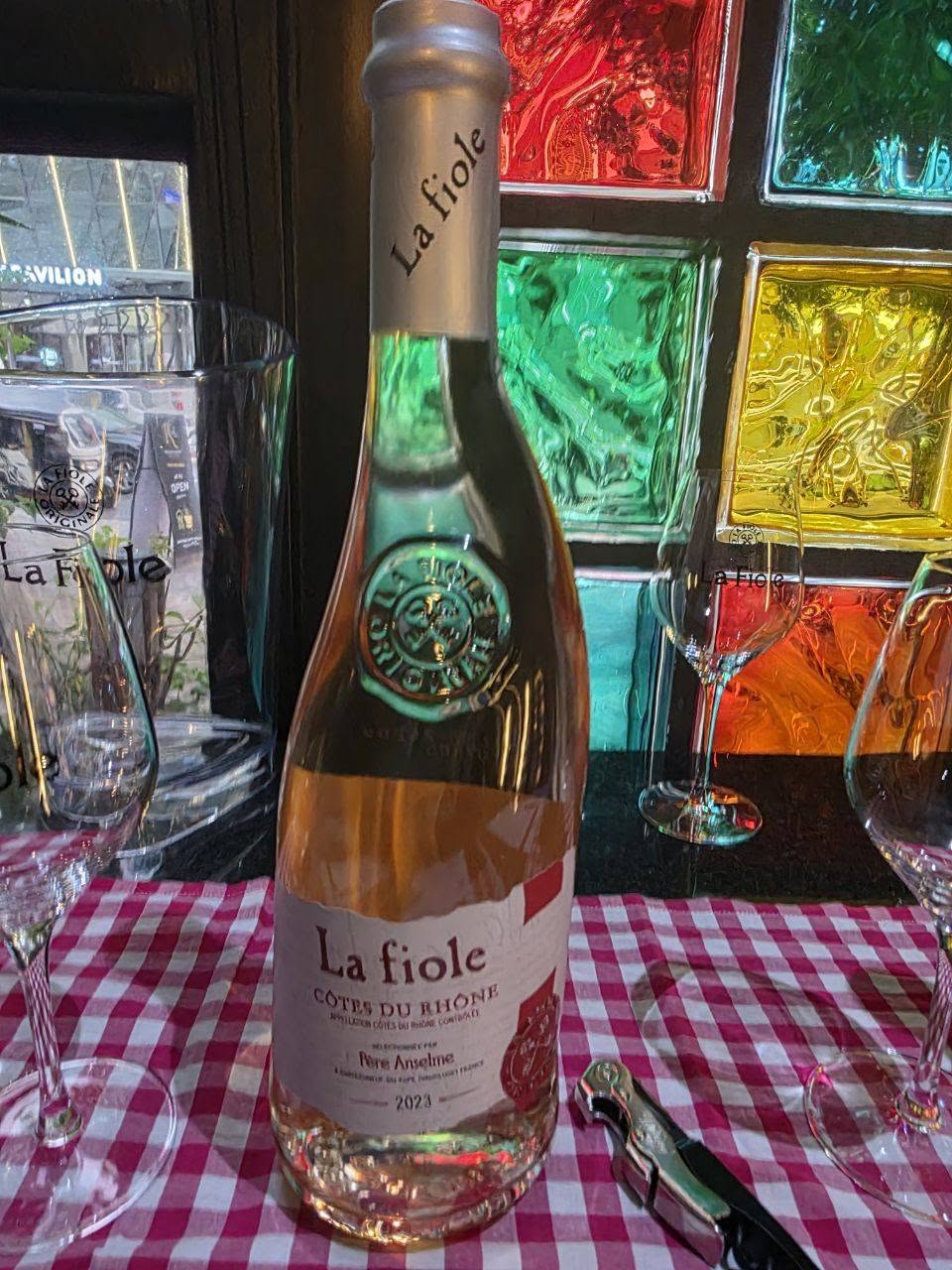 rosé wine bottle with glasses on checkered tablecloth