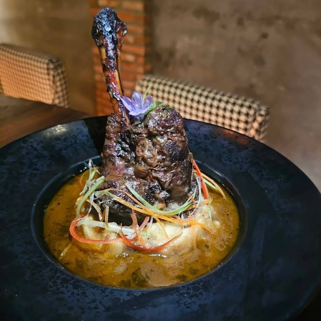 braised meat shank in sauce on dark plate